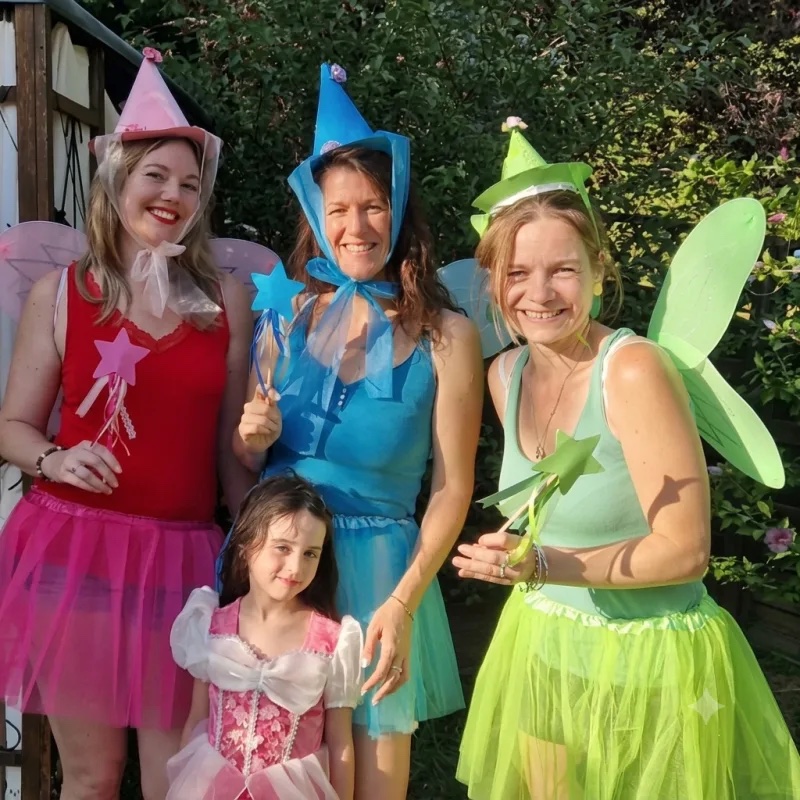 Animatrices costumées en fées et une enfant déguisée en fée dans un jardin, lors d'un anniversaire féérique pour enfant
