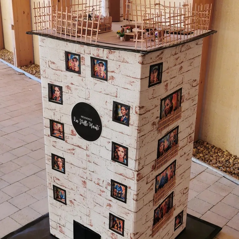 Décor d'enquête murder party : immeuble miniature présentant les portraits des suspects